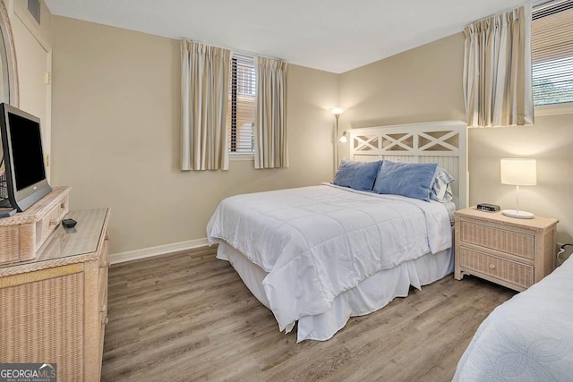 bedroom featuring multiple windows, wood finished floors, and visible vents