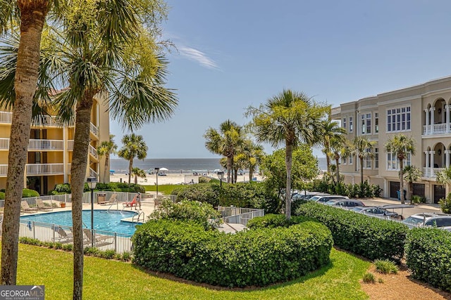 community pool with a water view and fence