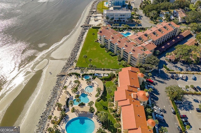 aerial view with a water view and a beach view
