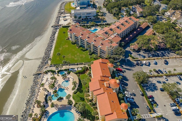 drone / aerial view featuring a water view and a view of the beach