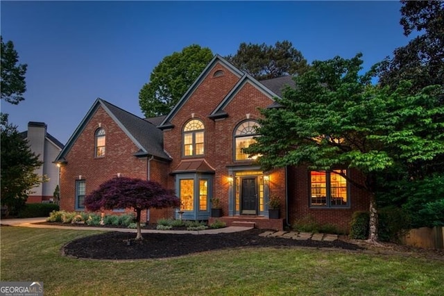 traditional-style home with a front lawn and brick siding