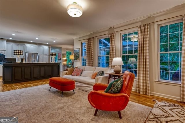 sitting room featuring baseboards, light wood-type flooring, and recessed lighting