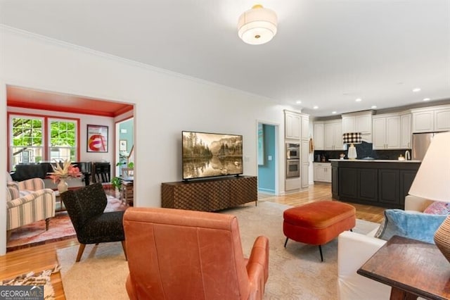 living area with ornamental molding, light wood-type flooring, and recessed lighting