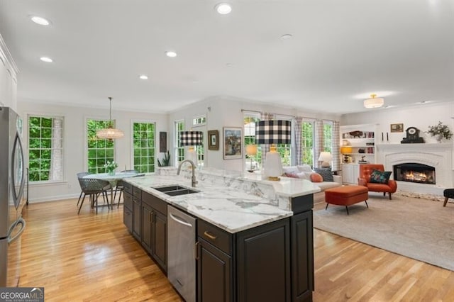 kitchen with appliances with stainless steel finishes, a sink, light wood-style floors, plenty of natural light, and recessed lighting