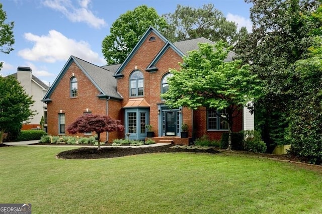 view of front of property featuring a front lawn and brick siding