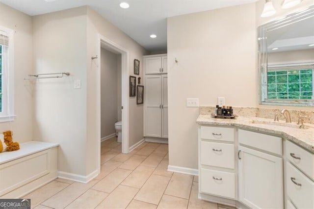 bathroom with vanity, toilet, recessed lighting, baseboards, and tile patterned floors