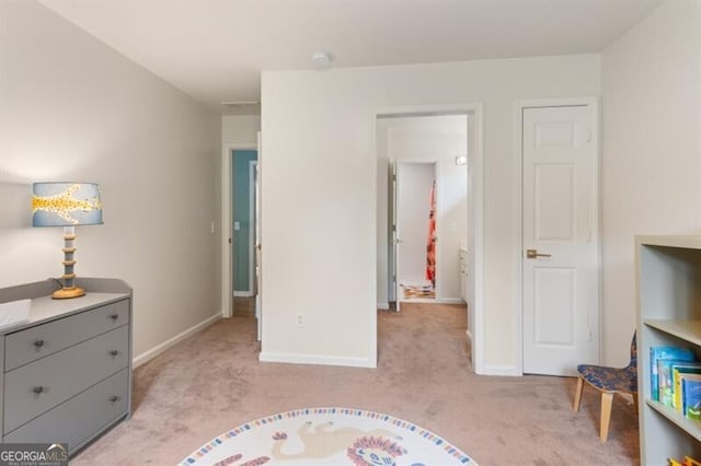 bedroom with light carpet and baseboards