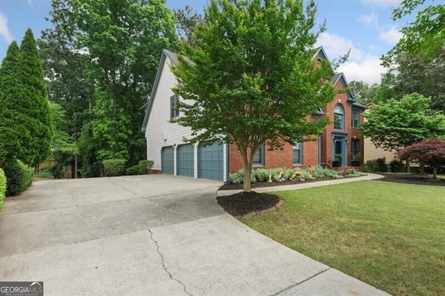 view of front of home with a garage, a front yard, concrete driveway, and brick siding