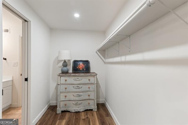 walk in closet with wood finished floors