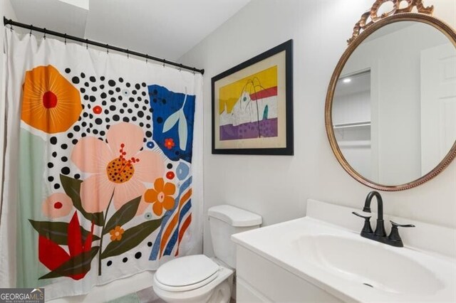 full bath featuring toilet, vanity, and a shower with curtain