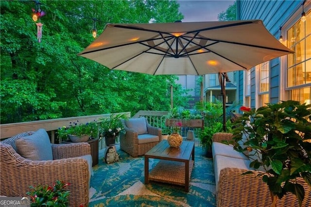 balcony at dusk with an outdoor hangout area and a patio