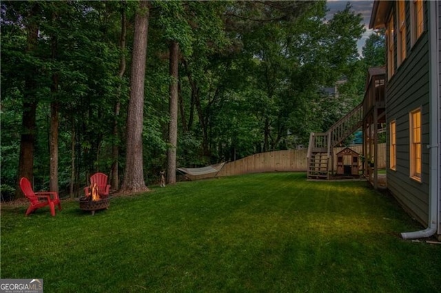 view of yard featuring an outdoor fire pit and stairs