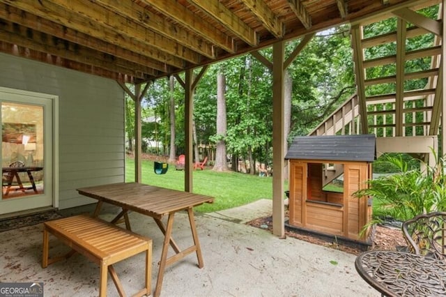 view of patio with outdoor dining area and an outbuilding