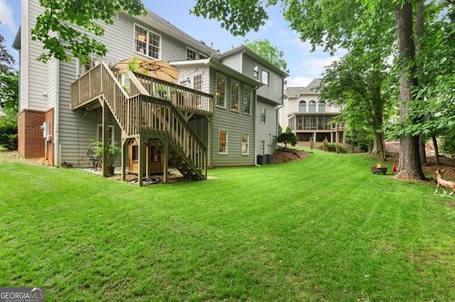 rear view of property with a wooden deck, stairs, a lawn, and a chimney