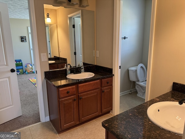 full bathroom with tile patterned flooring, a sink, baseboards, and two vanities