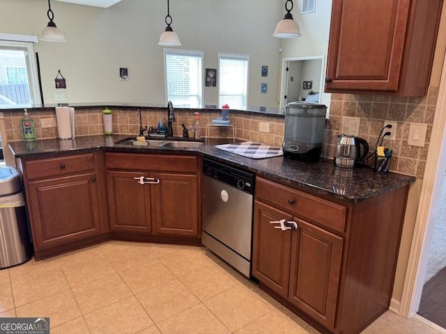 kitchen with stainless steel dishwasher, a sink, dark stone counters, and tasteful backsplash