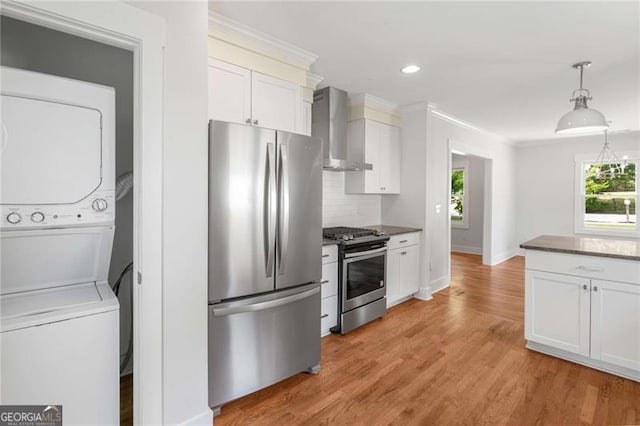 1798 S Gordon St SW, Atlanta, GA 30310 - kitchen with stacked washing maching and dryer, stainless steel appliances, white cabinets, wall chimney range hood, and decorative backsplash