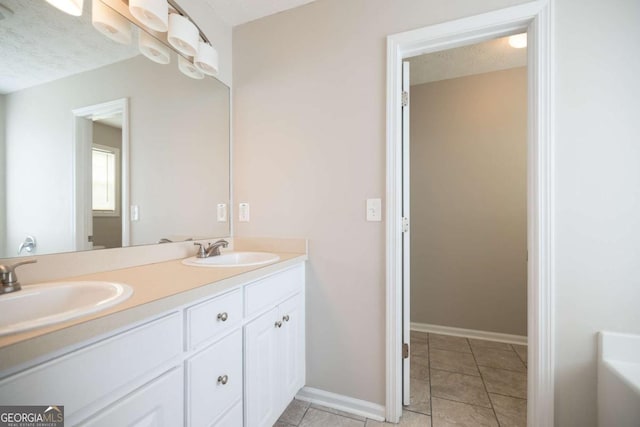 full bathroom featuring a sink, baseboards, tile patterned floors, and double vanity