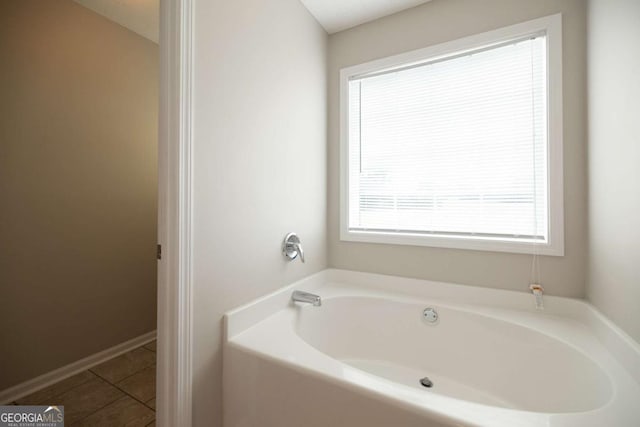 bathroom with tile patterned flooring and a bath