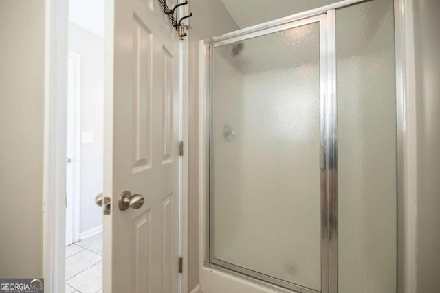 full bath featuring tile patterned floors and a shower stall
