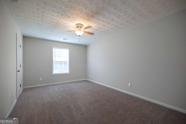 carpeted spare room with baseboards and a ceiling fan