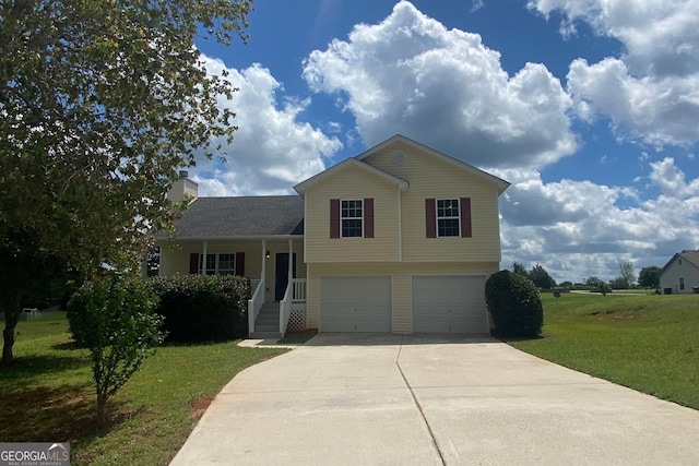 split level home featuring an attached garage, concrete driveway, a chimney, and a front yard