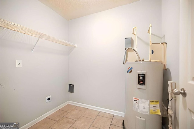 laundry room featuring laundry area, water heater, baseboards, light tile patterned floors, and hookup for an electric dryer