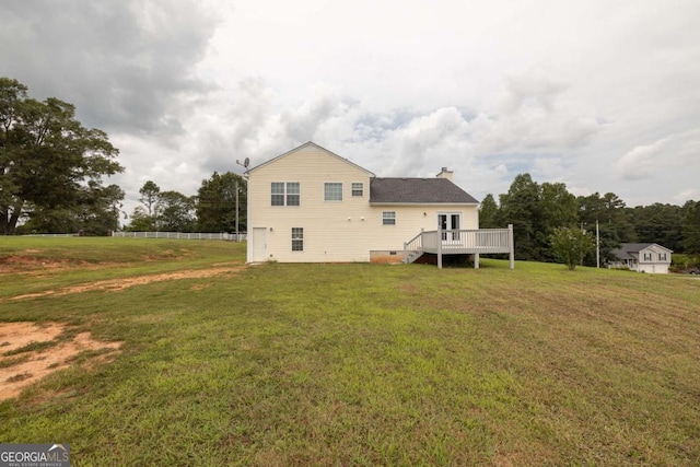 back of property featuring a lawn, a wooden deck, and a chimney