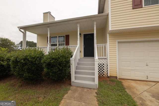 property entrance featuring an attached garage, covered porch, and a chimney
