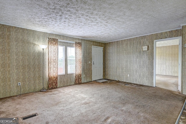 empty room with visible vents, carpet flooring, a textured ceiling, and crown molding