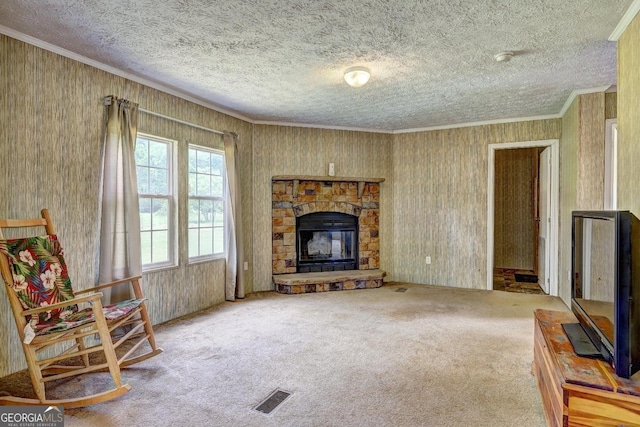 carpeted living room featuring a textured ceiling, a stone fireplace, visible vents, and ornamental molding