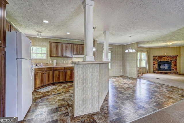 kitchen featuring freestanding refrigerator, a textured ceiling, and plenty of natural light
