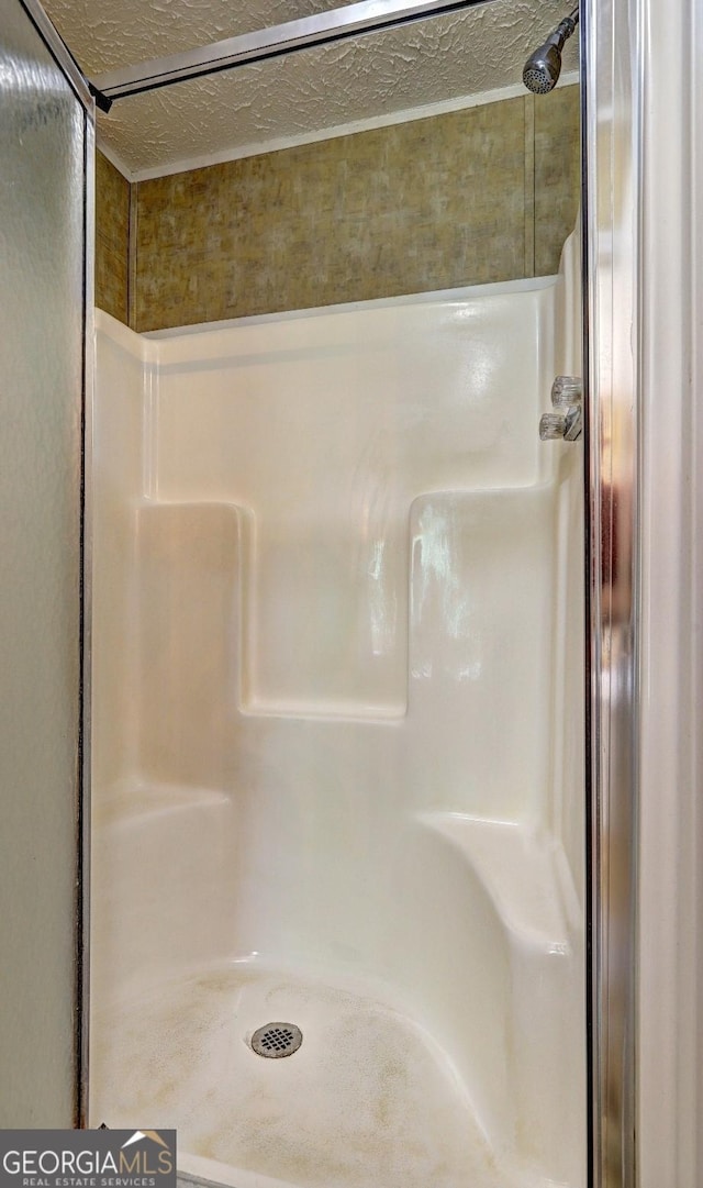 bathroom featuring a shower stall and a textured ceiling