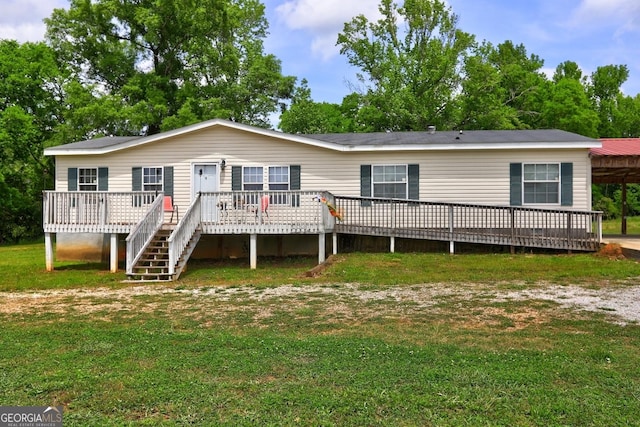 back of property with a yard, a wooden deck, and a carport
