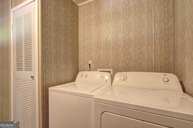 clothes washing area with laundry area, independent washer and dryer, and wallpapered walls