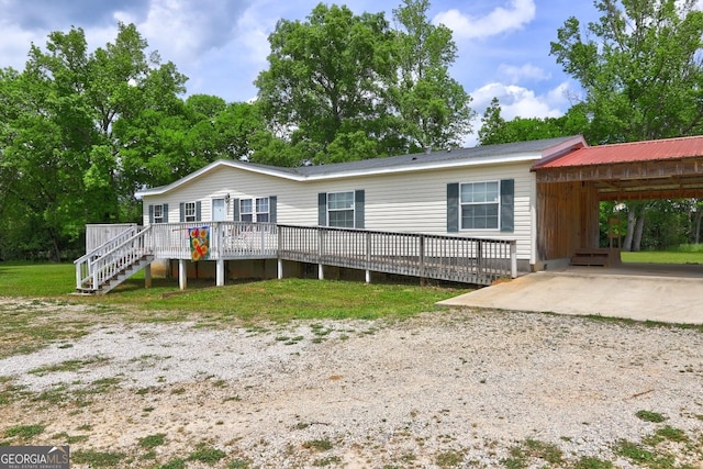 view of front facade with a carport, driveway, and a deck