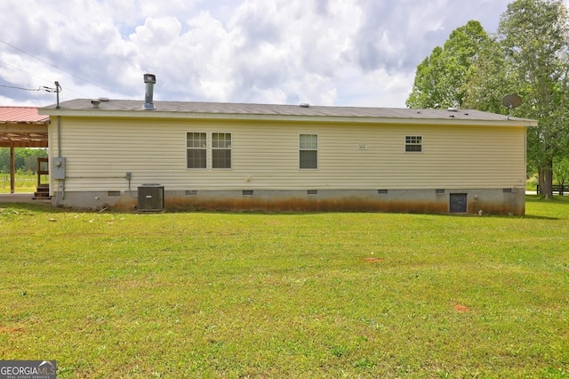 back of property with a lawn, crawl space, and central AC unit