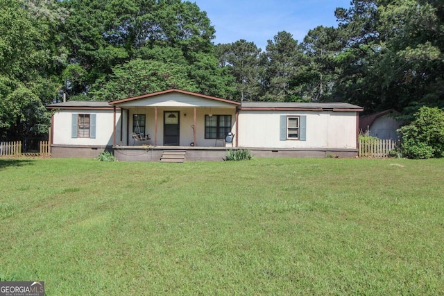 manufactured / mobile home featuring a front lawn, fence, covered porch, and crawl space