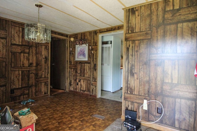 interior space featuring wood walls and a notable chandelier