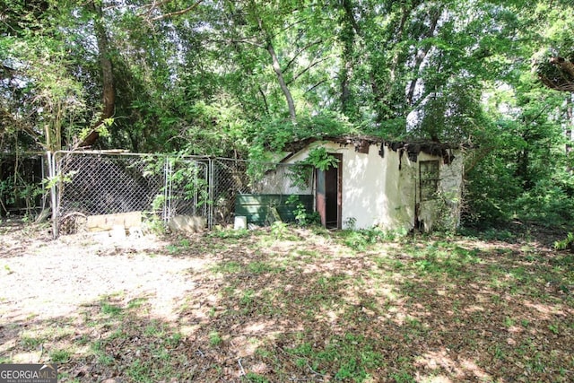 view of yard with an outdoor structure, fence, and a storage shed