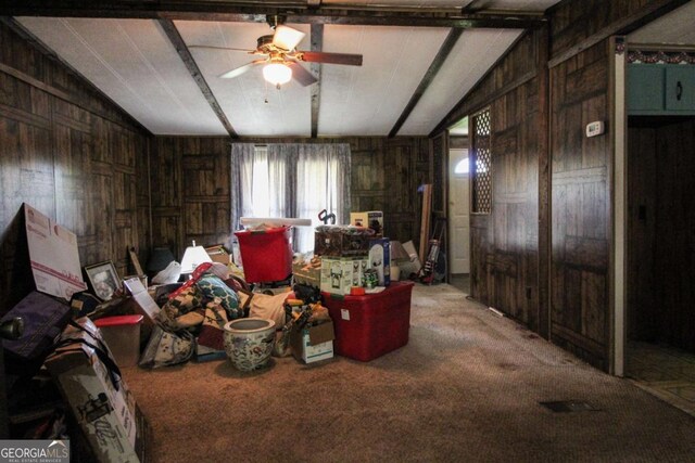 miscellaneous room featuring carpet flooring, a ceiling fan, lofted ceiling, and wooden walls