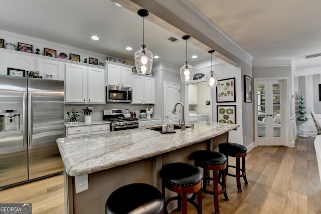 kitchen featuring visible vents, a sink, white cabinetry, and stainless steel appliances