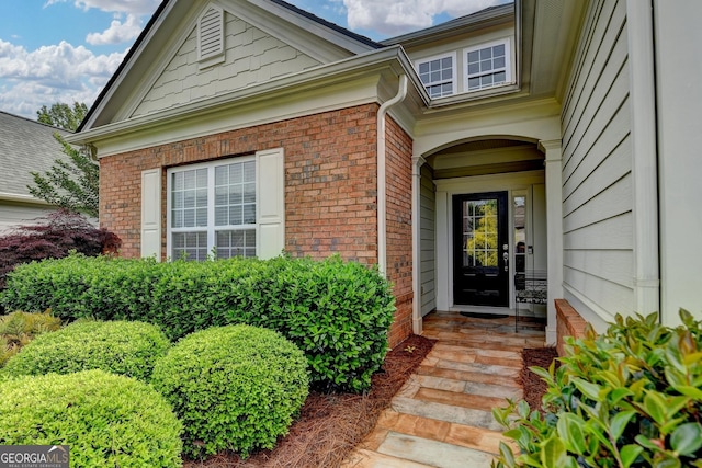 view of exterior entry featuring brick siding