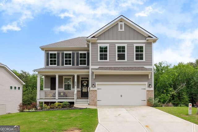 craftsman-style house featuring covered porch, driveway, a garage, brick siding, and a front lawn