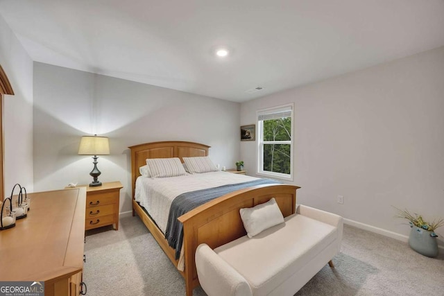 bedroom with baseboards, visible vents, and light carpet