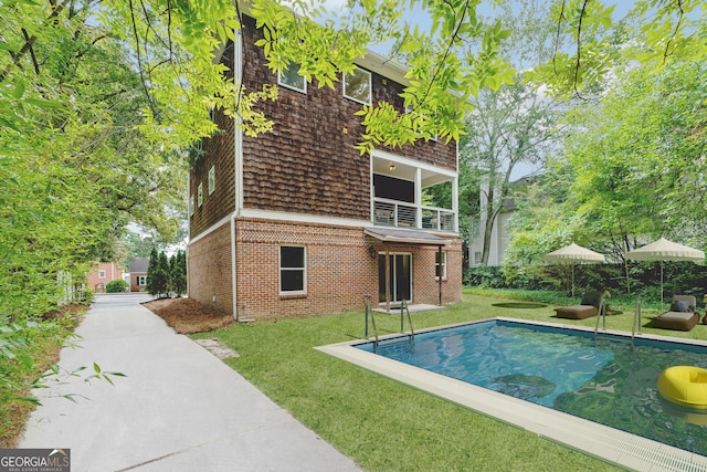 1303 N Druid Hills Rd, Brookhaven, GA 30319 - rear view of house featuring a yard, brick siding, a balcony, and an outdoor pool