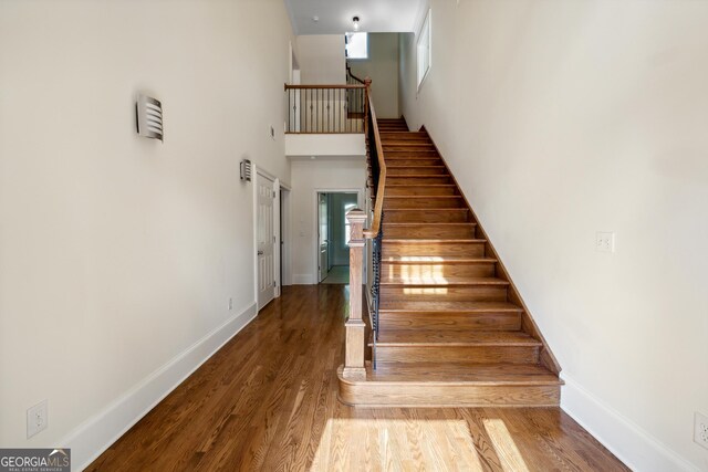 1303 N Druid Hills Rd, Brookhaven, GA 30319 - stairway with baseboards, a towering ceiling, and wood finished floors