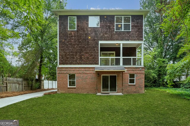 1303 N Druid Hills Rd, Brookhaven, GA 30319 - rear view of property featuring a lawn, fence, brick siding, and a balcony