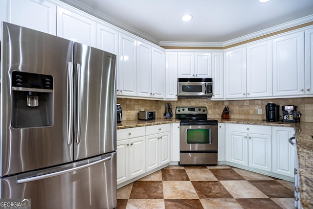 kitchen featuring decorative backsplash, stainless steel appliances, and white cabinetry