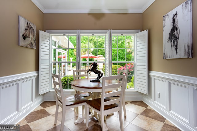 dining room featuring crown molding, a wealth of natural light, and a decorative wall